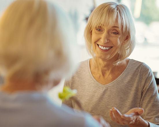 Positive aged woman talking to her friend